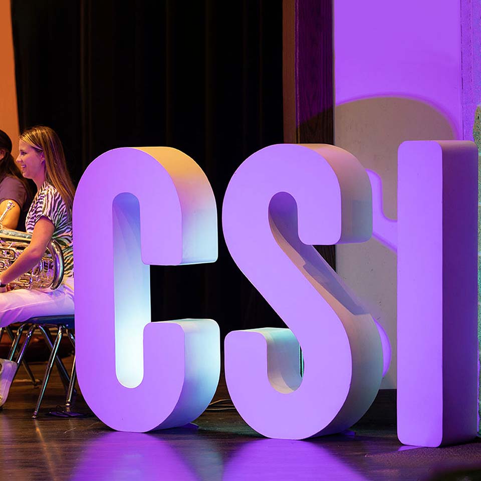 The large CSI letters on stage