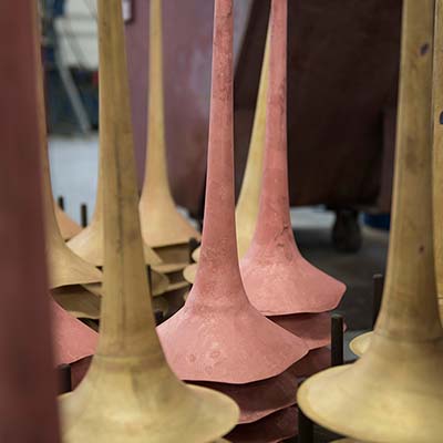 Rough, unfinished, trumpet bells on factory rack